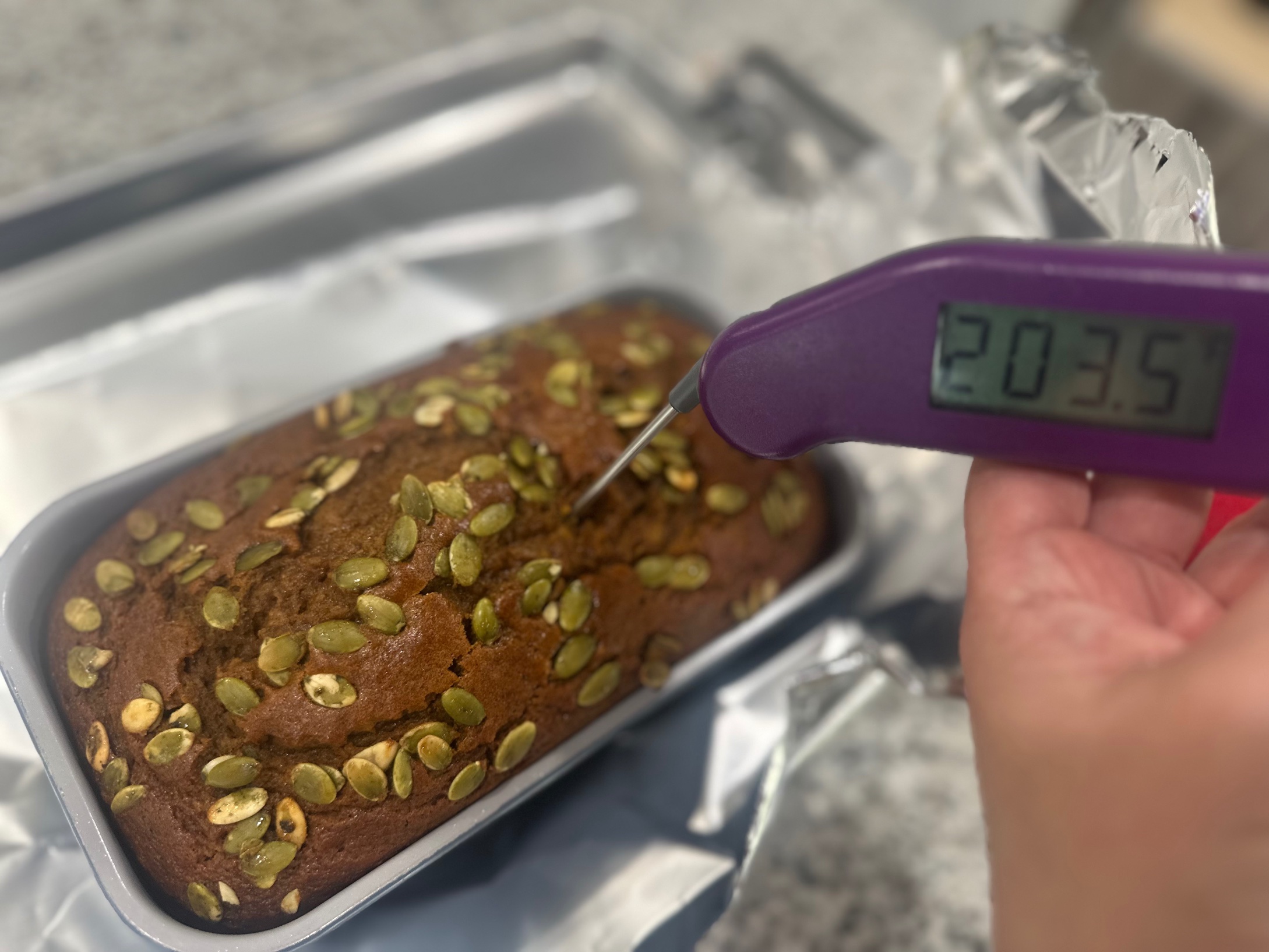 Digital thermometer reading 203.5 degrees in pumpkin bread