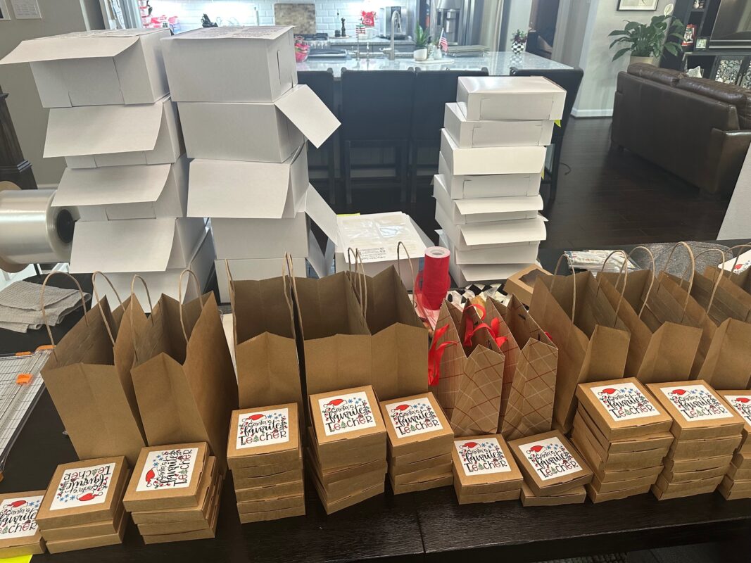Tall stacks of white bakery boxes and rows of packed cookie orders ready for pickup