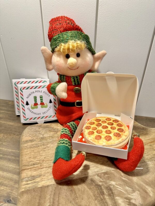 Elf on the Shelf holding a North Pole Pizza delivery box with a pizza cookie